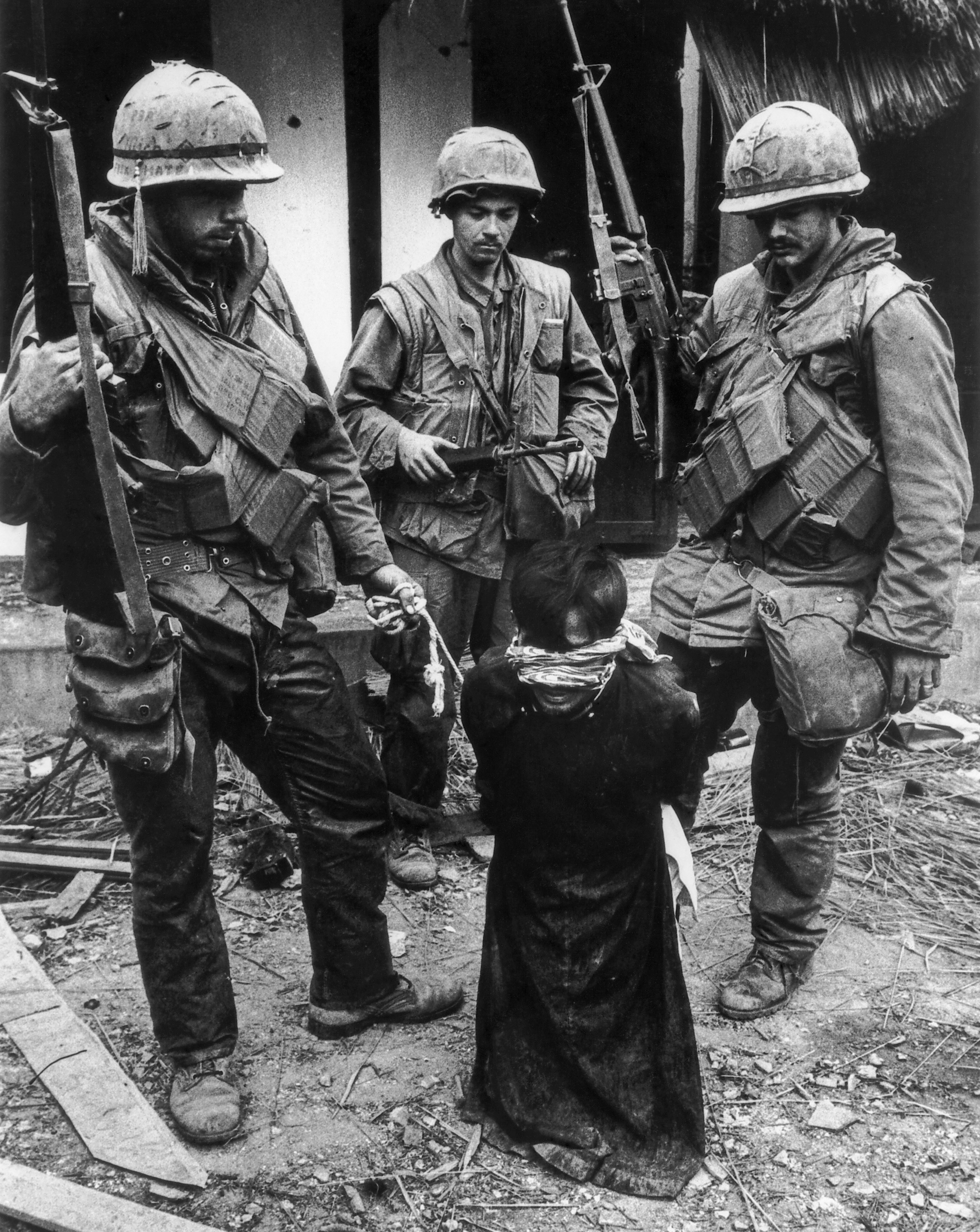 U.S. Marines guarding a blindfolded Vietnamese civilian during the Tet Offensive in Hue.