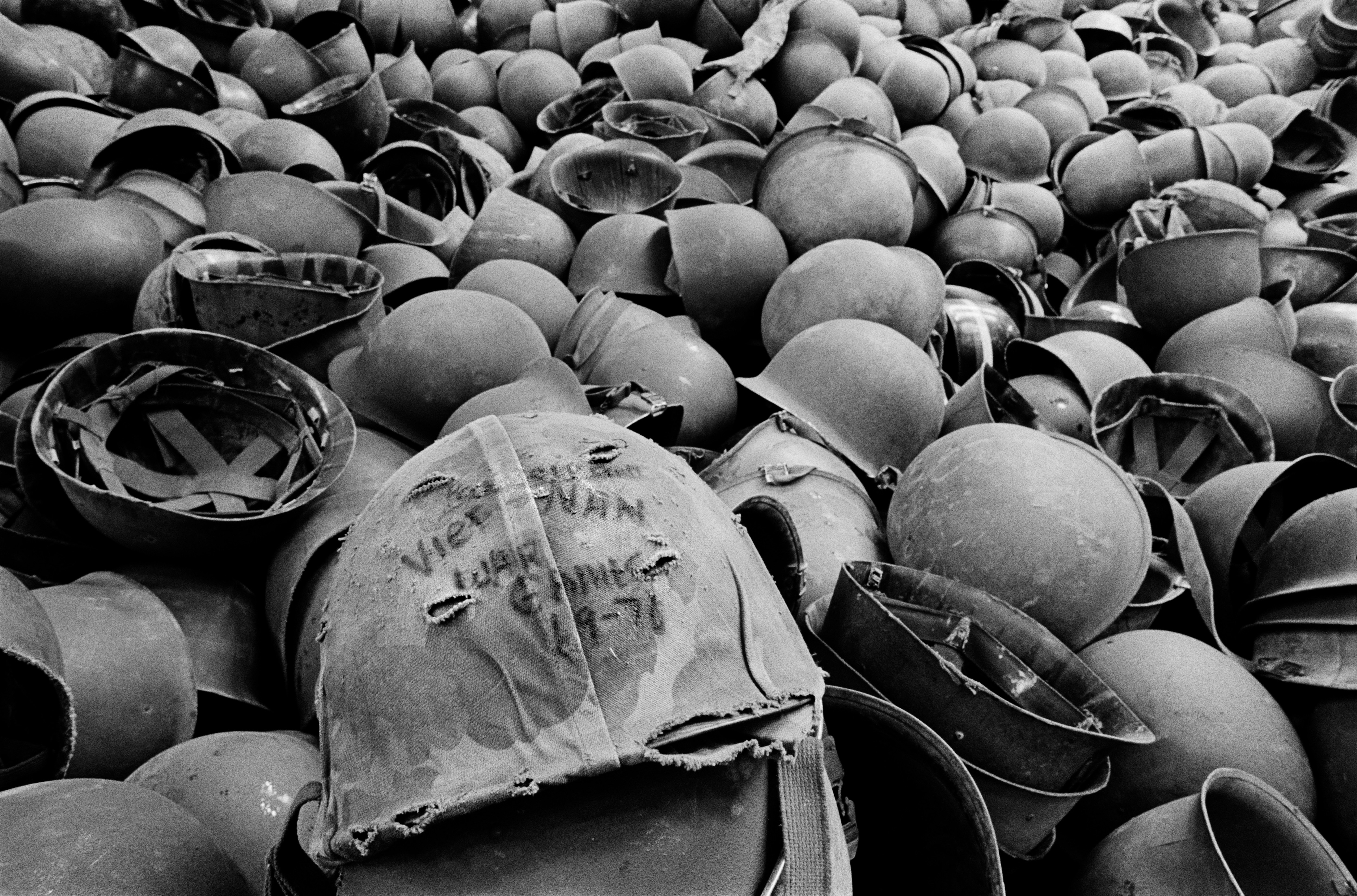 Discarded military helmets on the ground.