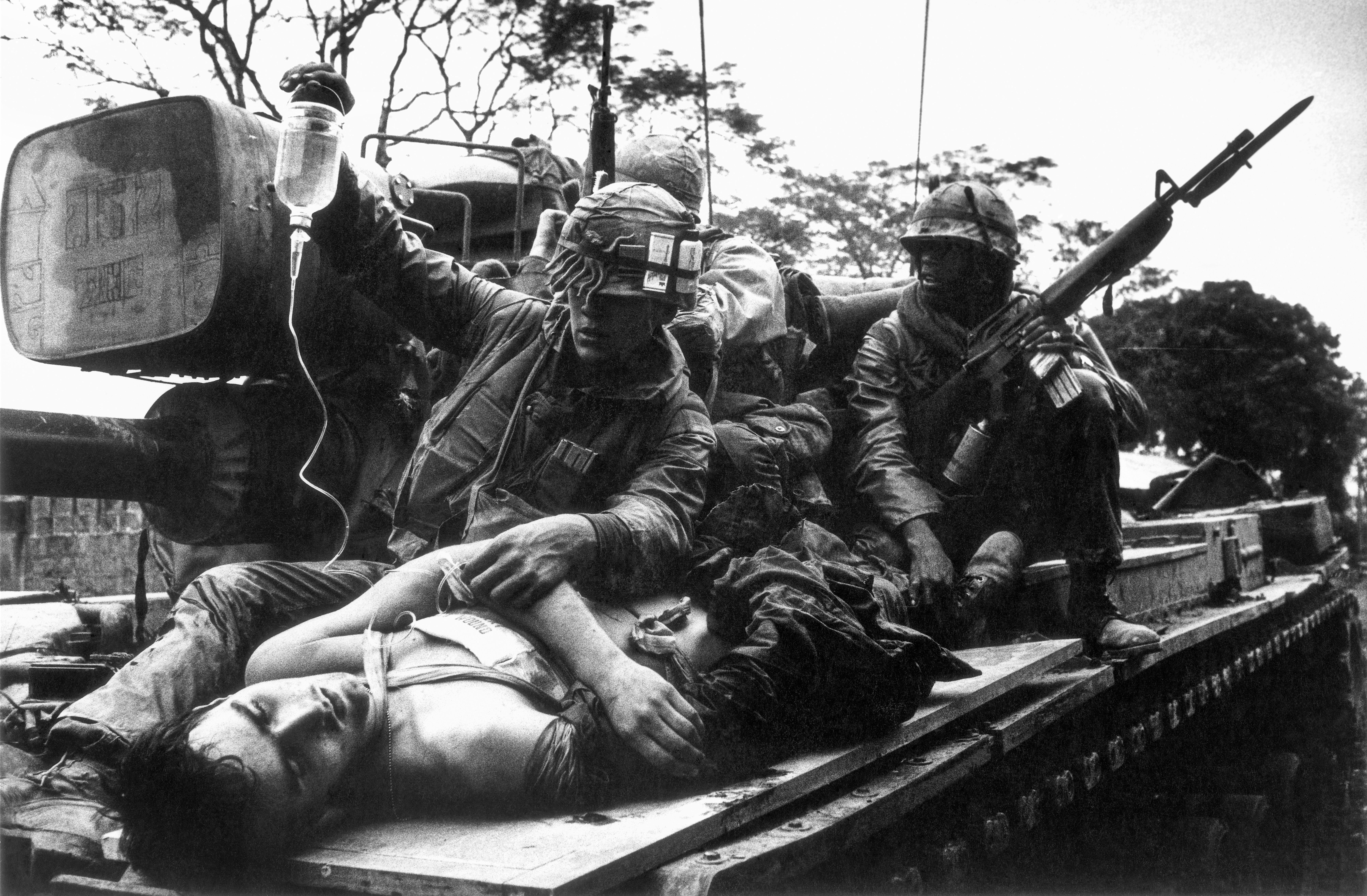 A dying U.S. Marine being carried by a tank through the ruins of the Citadel during the Battle of Hue in the Vietnam War.