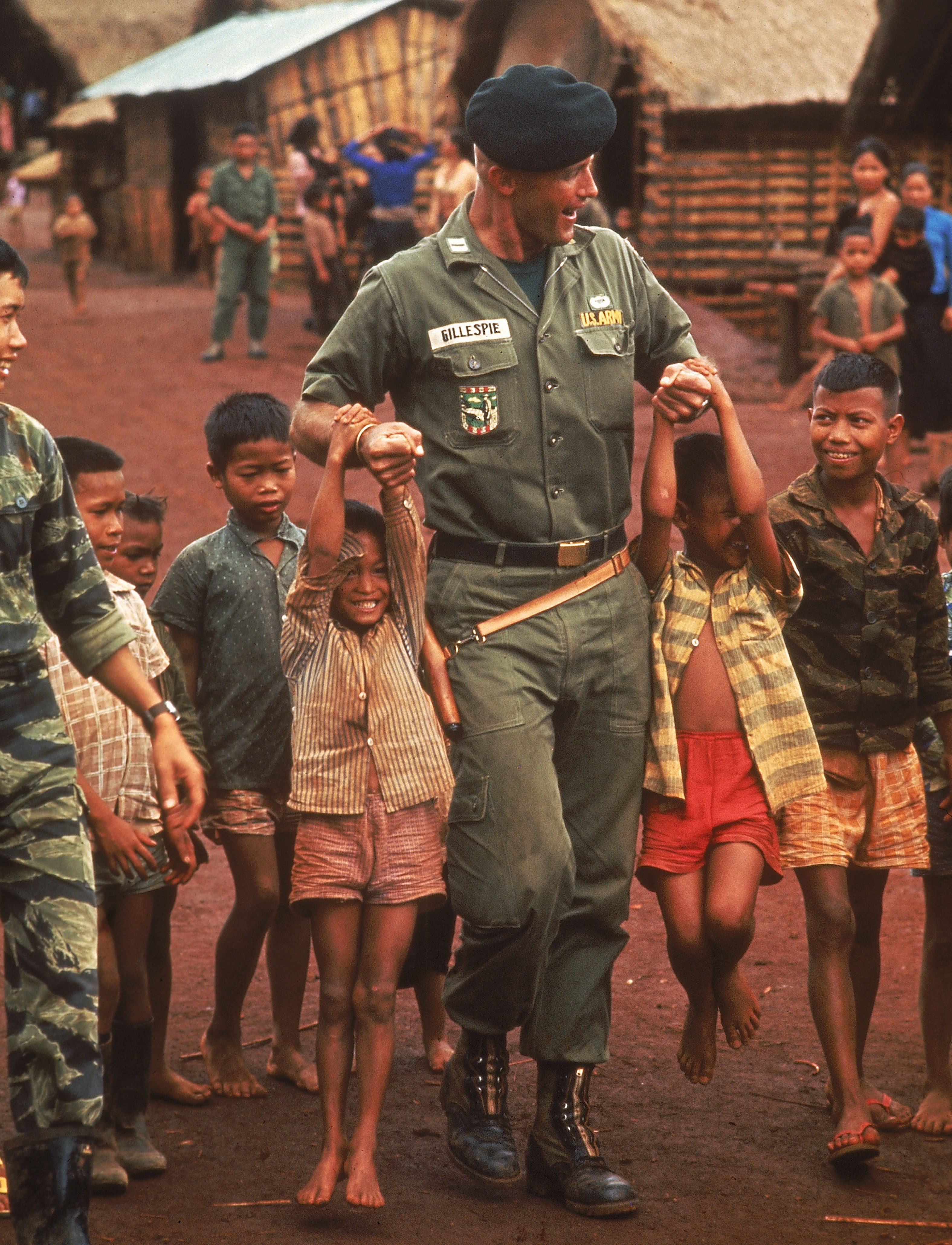 A U.S. Army advisor plays with Vietnamese children.